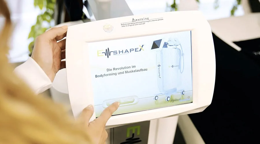 Das Bild zeigt, wie eine Mitarbeiterin das EMShapeX®-Display bedient.